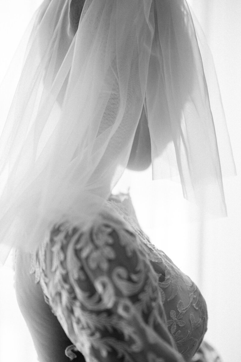 Artistic and refined photo of a bride getting ready in a delicate gown, captured by a luxury wedding photographer in a stylish Montreal hotel.