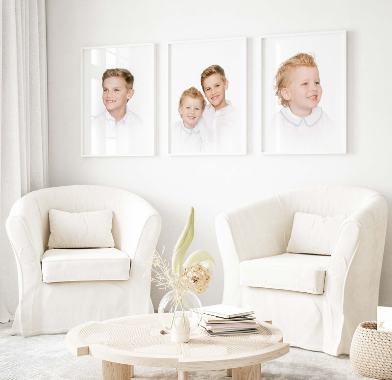 A gorgeous room with two white swivel chairs features three white framed heirloom portraits taken by Morgan Leigh Photography in Baton Rouge, LA.