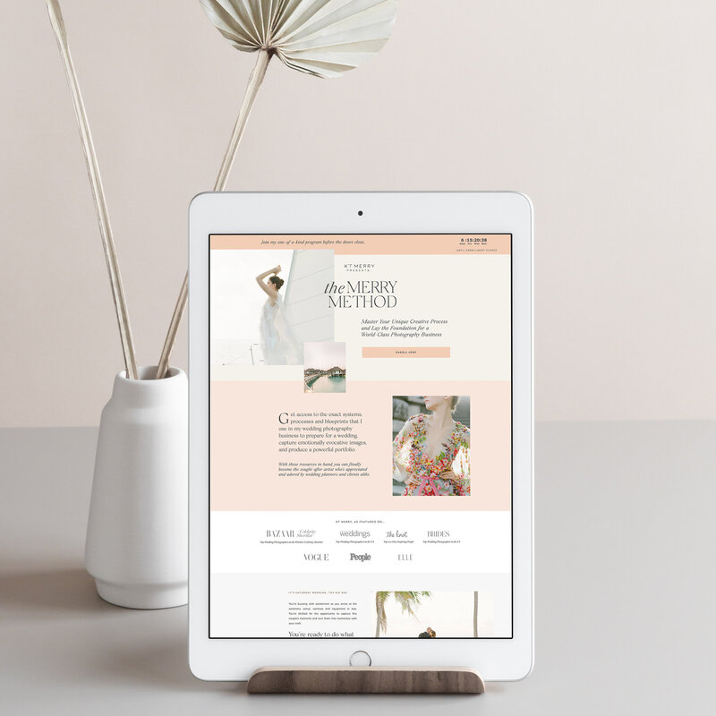 Website open on a white iPad next to a white vase