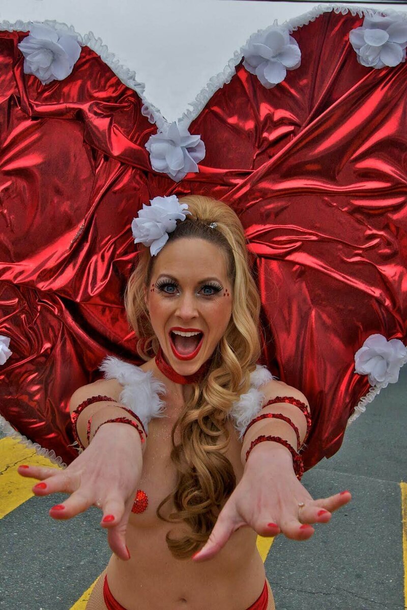Cherish performing in red heart-themed burlesque costume with arms outstretched