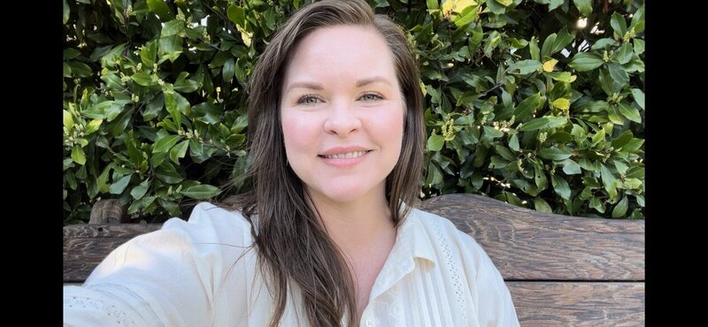 Michelle-Marie Gilkeson  in a lavender embroidered top smiling at camera