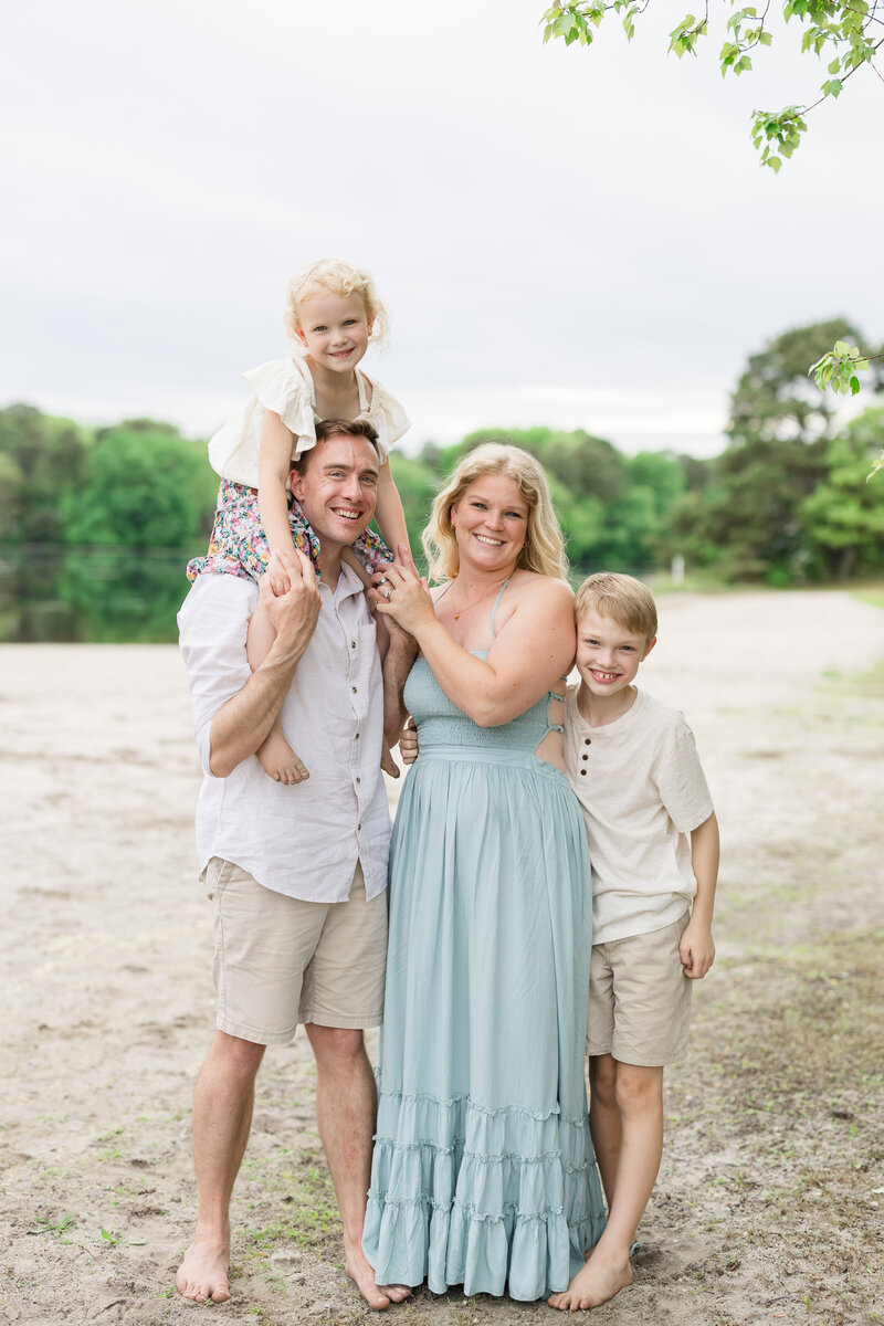 A family of four pose on the sand of Saginaw Bay