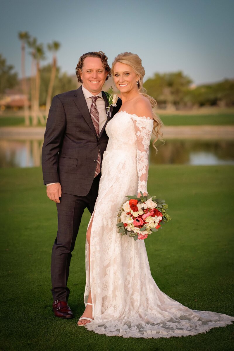 Bride and groom pose for portrait on their wedding day on golf course