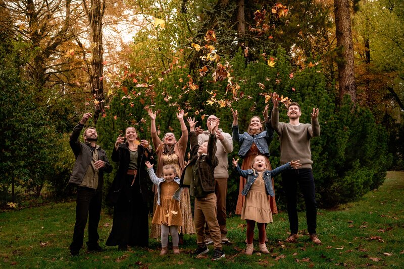 extended family throwing Autumn leaves