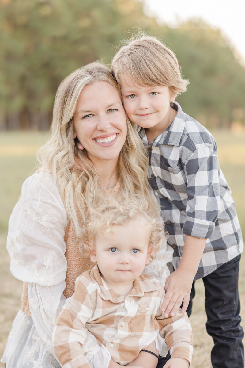 Mother smiling for portrait with two sons. - Family Photographer Greenville SC
