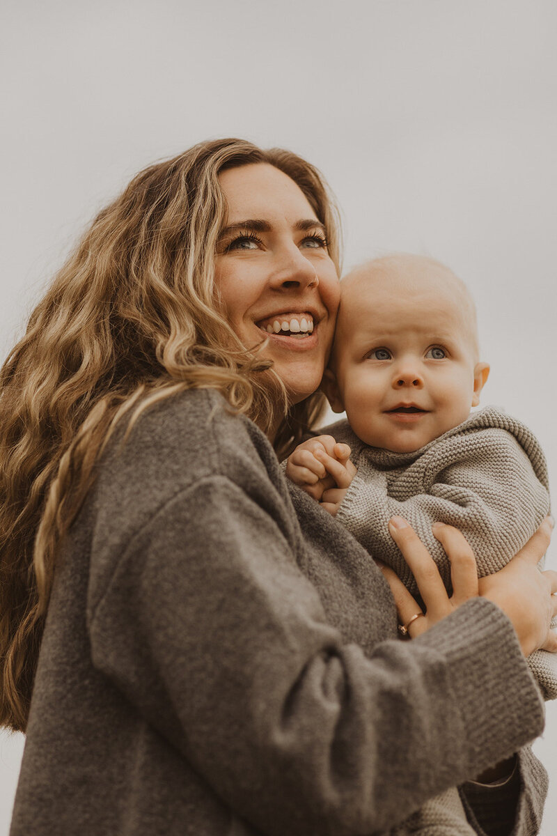 Minnesota photographer smiles into the distance while holding her baby