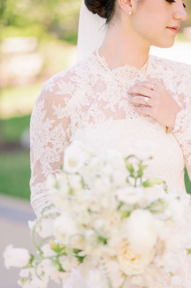 a bride holding a flower bouquet while posing in her wedding dress