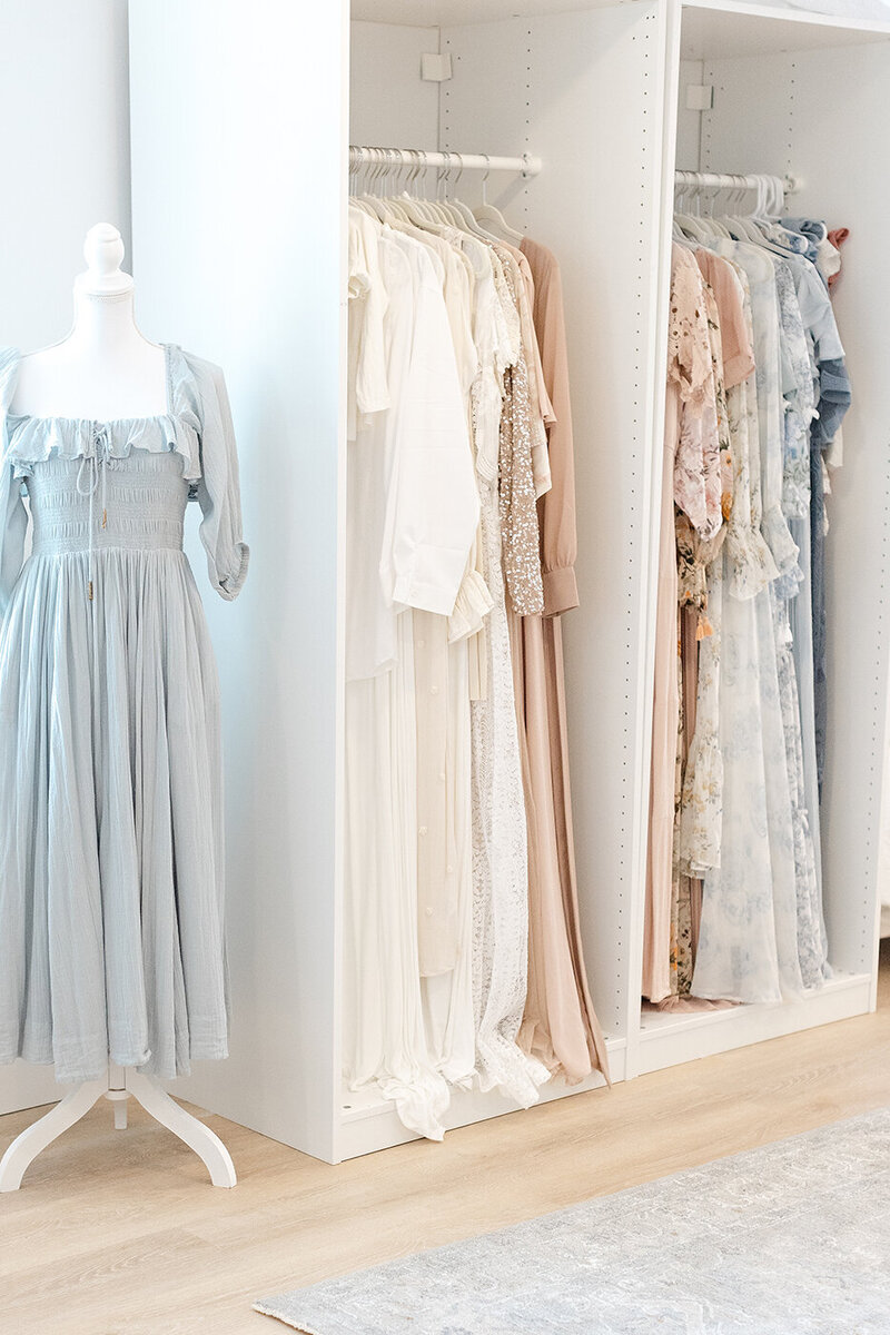 dresses hanging on rack in photographer newborn studio