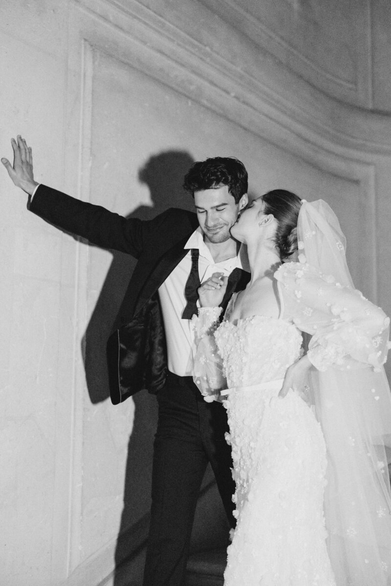 Black and white portrait of a bride and groom kissing