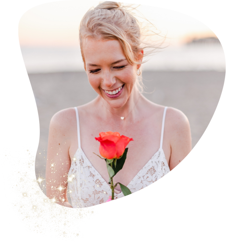 Woman holding a single orange rose while smiling