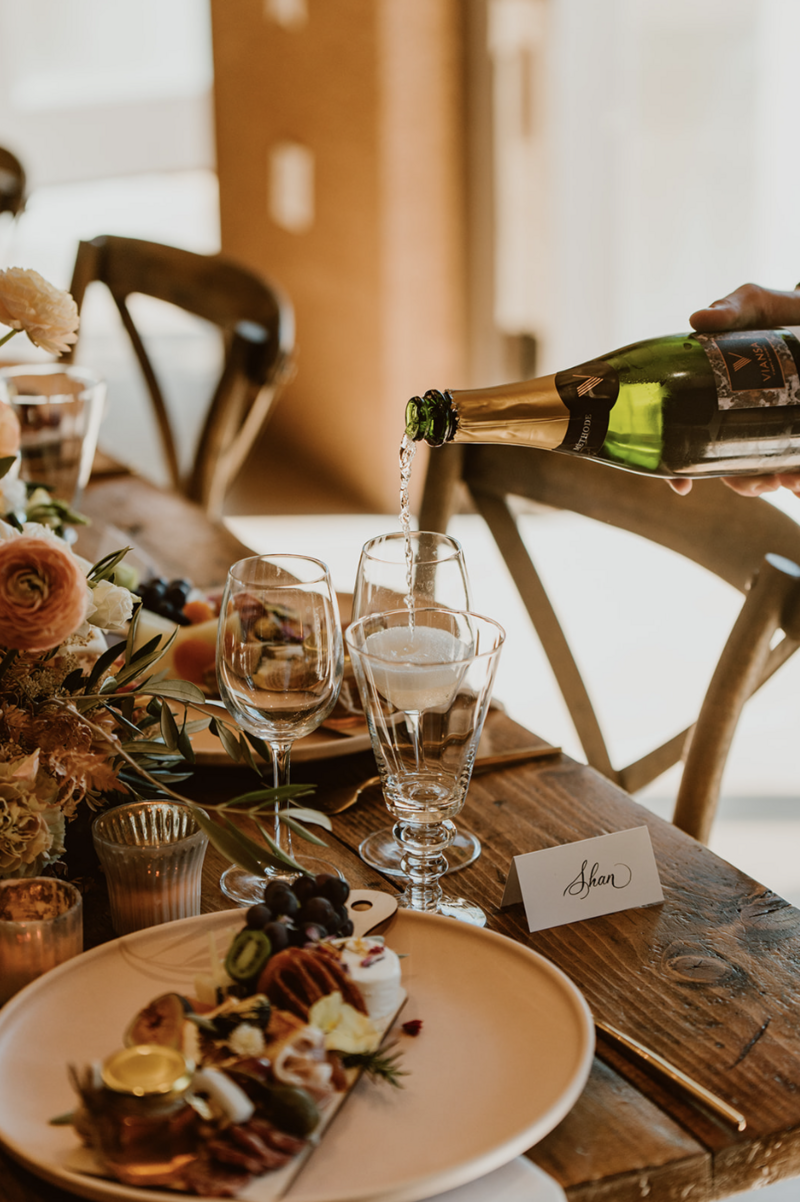 Champagne being poured for a luxury charcuterie elopement lunch at Viansa winery in Sonoma, CA