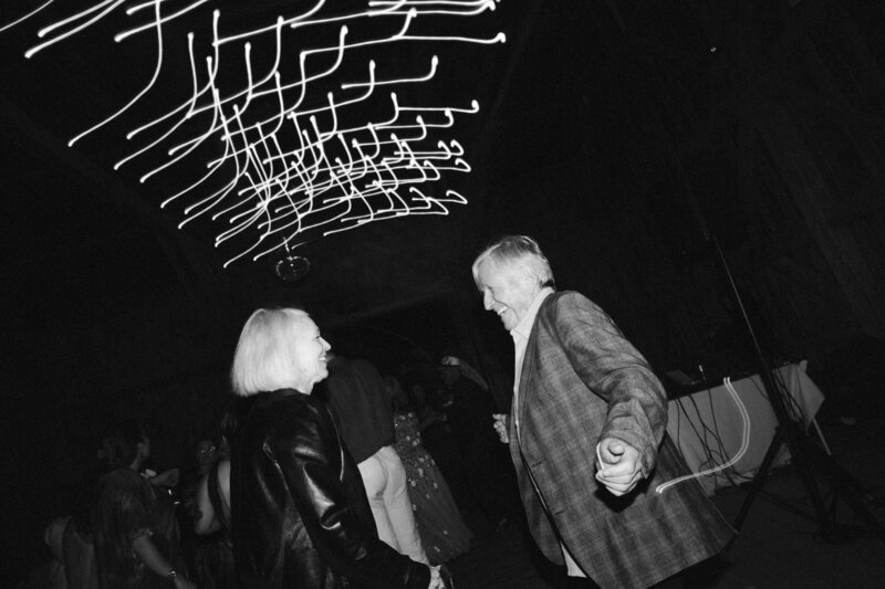 black and white photo of guests dancing and having fun at wedding reception