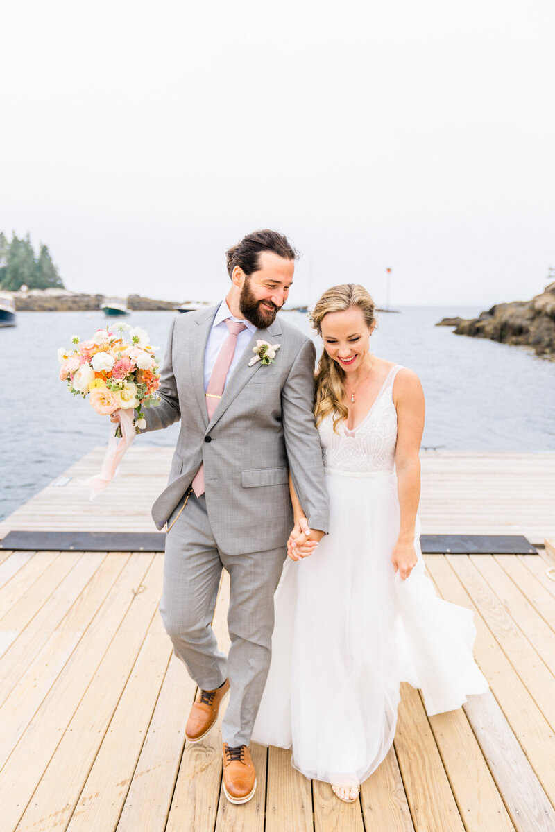 Couple walking on a dock on their elopement day | Maine elopement photographer | Adventure and Vows