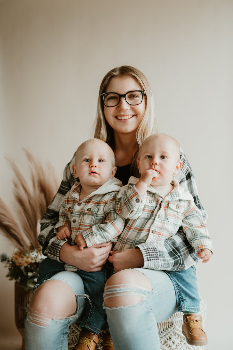 Mom with twin sons with neutral background in flannels