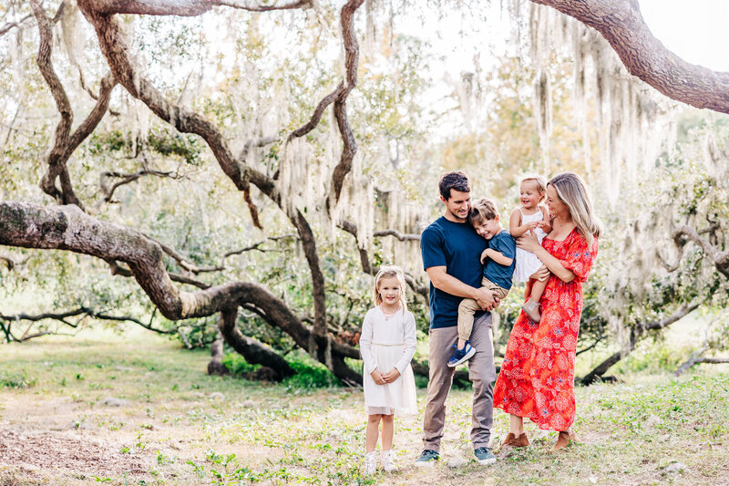 Family enjoying a relaxed holiday photoshoot surrounded by nature in Safety Harbor.