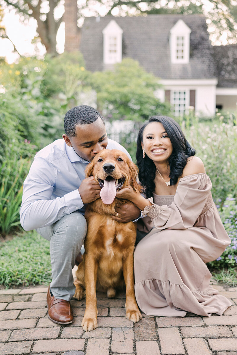 husband and wife pose together with dog for engagement photos