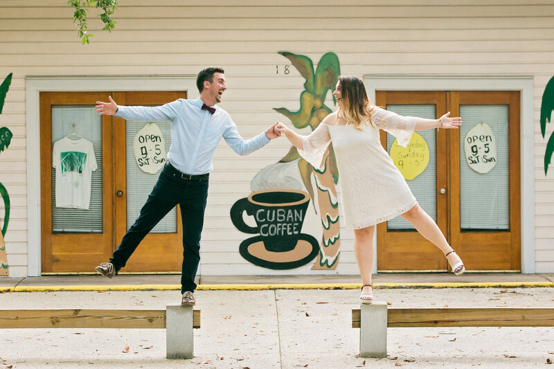 Couple smiling at each other posing in front of coffee shop