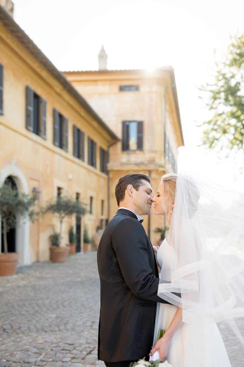 bride and groom kiss outside Italian wedding venue