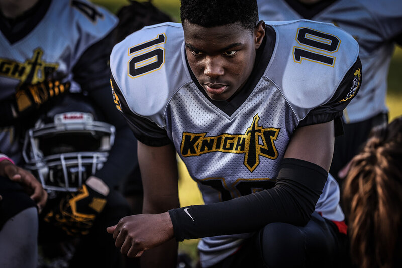 Football player crouching with elbow on knee