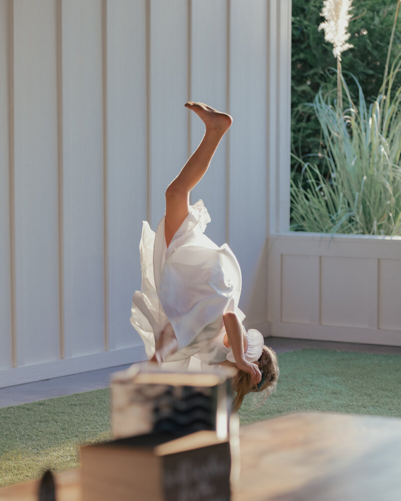 A little girl does a cartwheel outside during a catholic wedding reception at Tims Ford Lake in Decherd, Tennessee