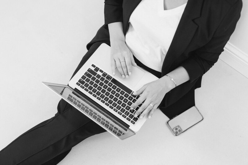 ys_emprendimiento_trabajando en laptopn desde le piso con suit negro