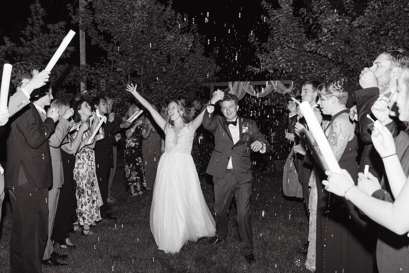 joyful grand exit with bubbles from a colorado wedding at stone mountain lodge