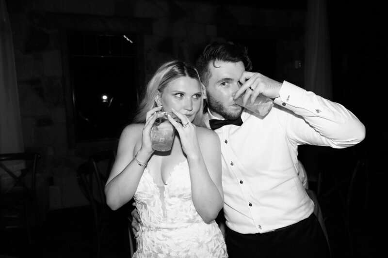 Editorial black and white photo of bride and groom sipping cocktails at their wedding reception – captured by Madison Dodd Photo in Texas
