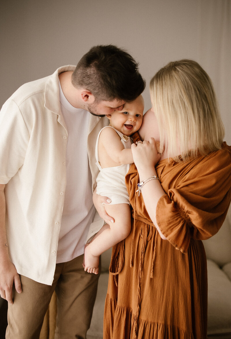 a gif of aimee kelly adjusting the baby before moving back to take another photograph