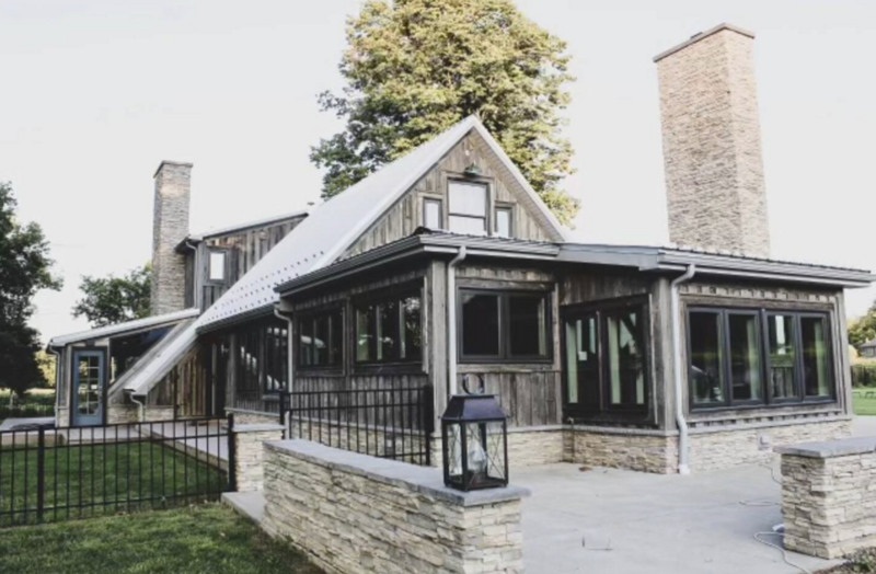 Modern rustic Estate with large windows, stone chimneys, and a spacious patio area at Bear Ridge Destination event venue.