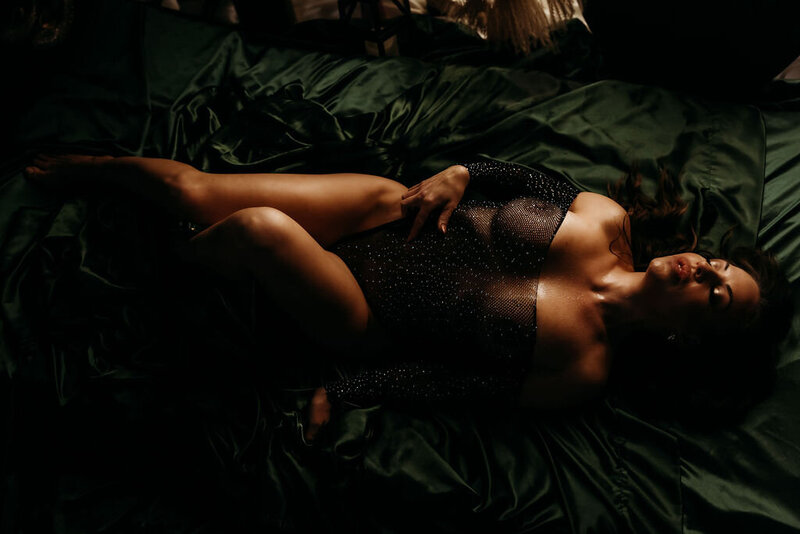 Boudoir photography woman in black lingerie on green sheets in bed in Lubbock, Texas Boudoir photographer in Amarillo TX