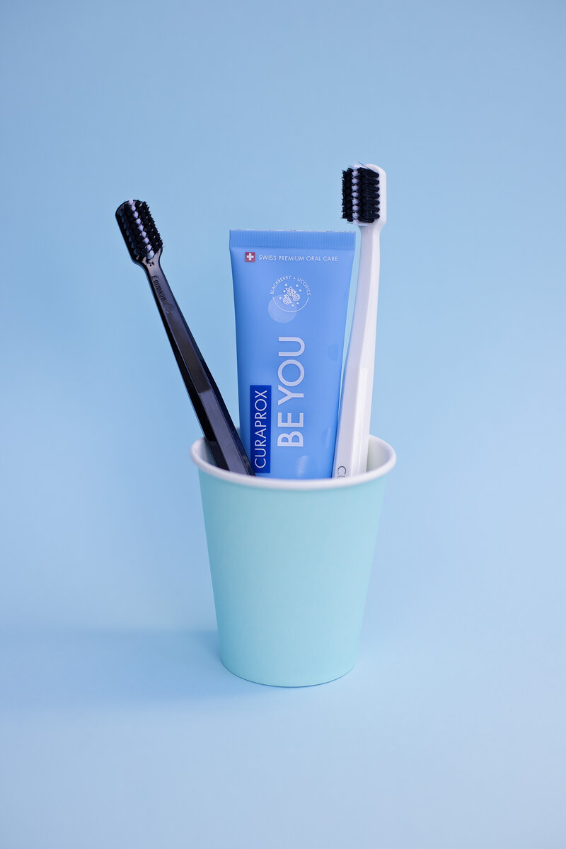 tooth brushes and toothpaste in cup