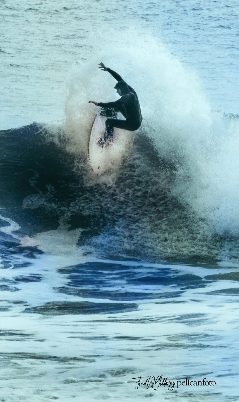 Surfer dude rides the high surf at famous Steamer Lane at Santa Cruz, CA.