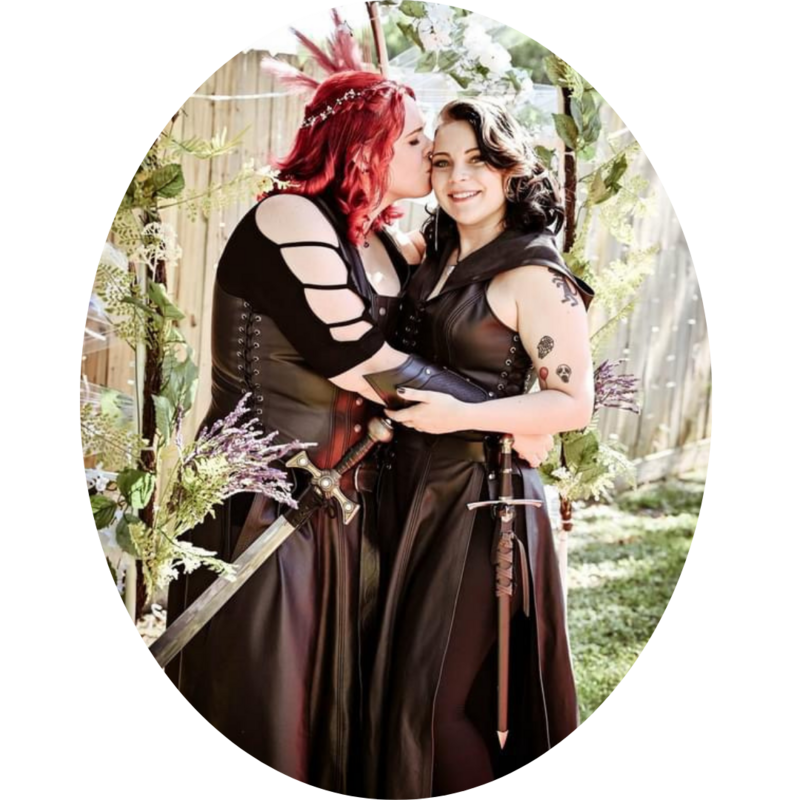 Renaissance pirate-themed lesbian wedding with sword accessories and custom hairstyling by traveling Las Vegas bridal stylist