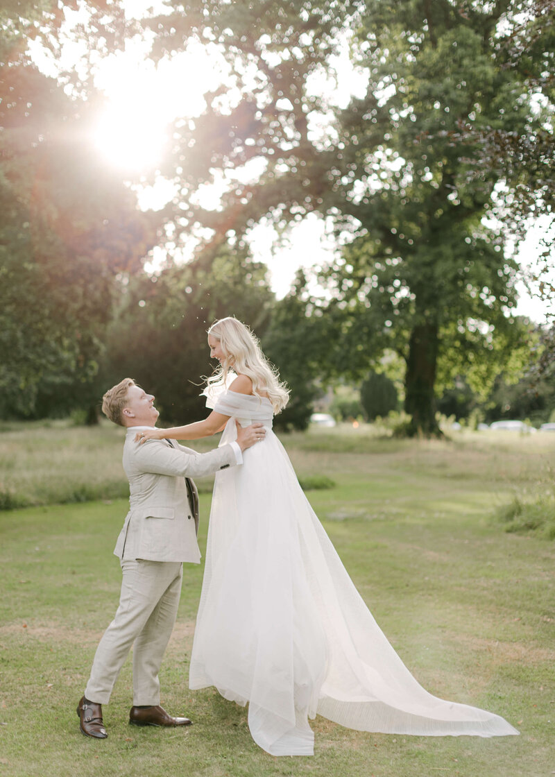 chloe-winstanley-weddings-grittleton-house-gardens-couple-lift-newhite-dress