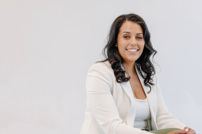 portrait of a woman with dark hair and a white blazer
