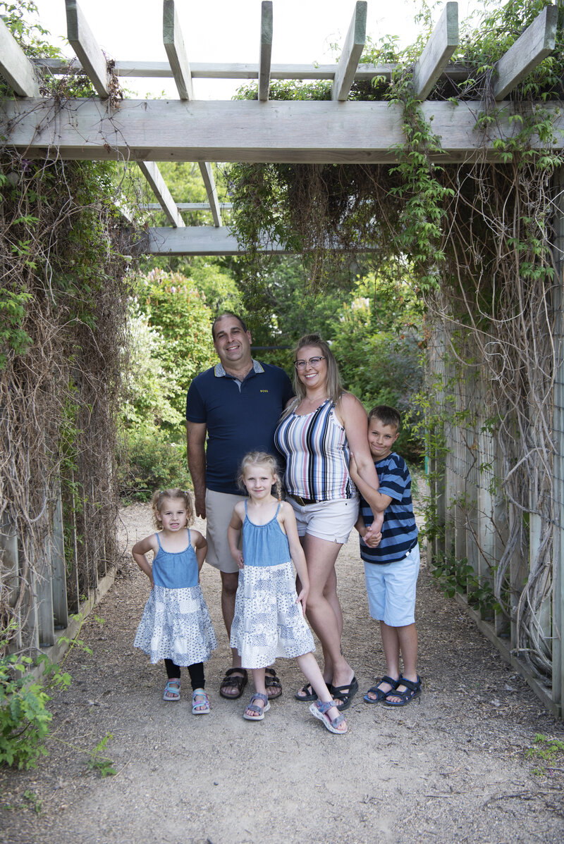 Family of 5 stranding close together on a ramp.