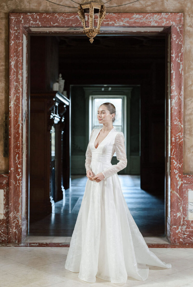 bride showing front of wedding dress in mansion