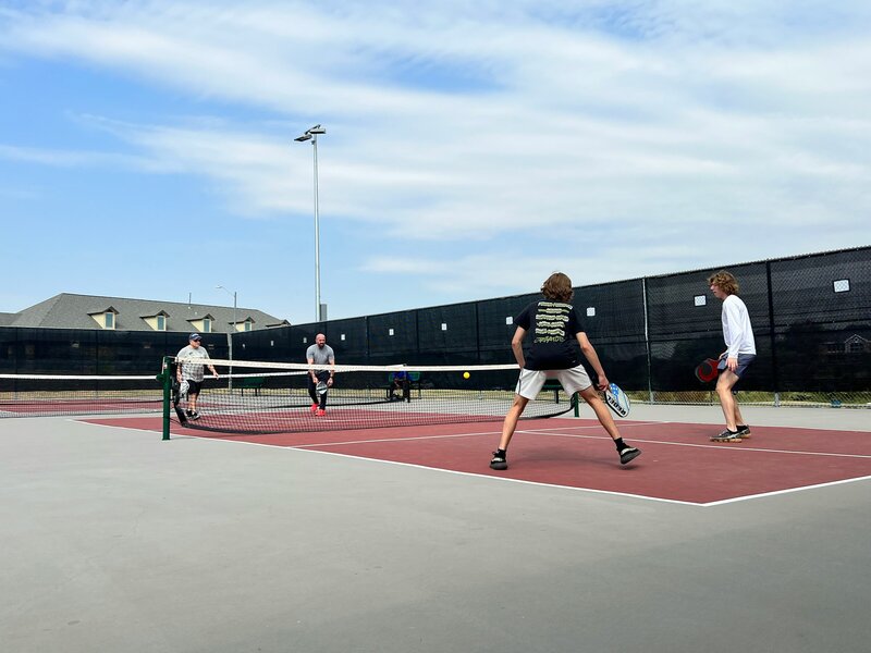 family playing pickleball - image credit leslu whitecotton free for use unsplash