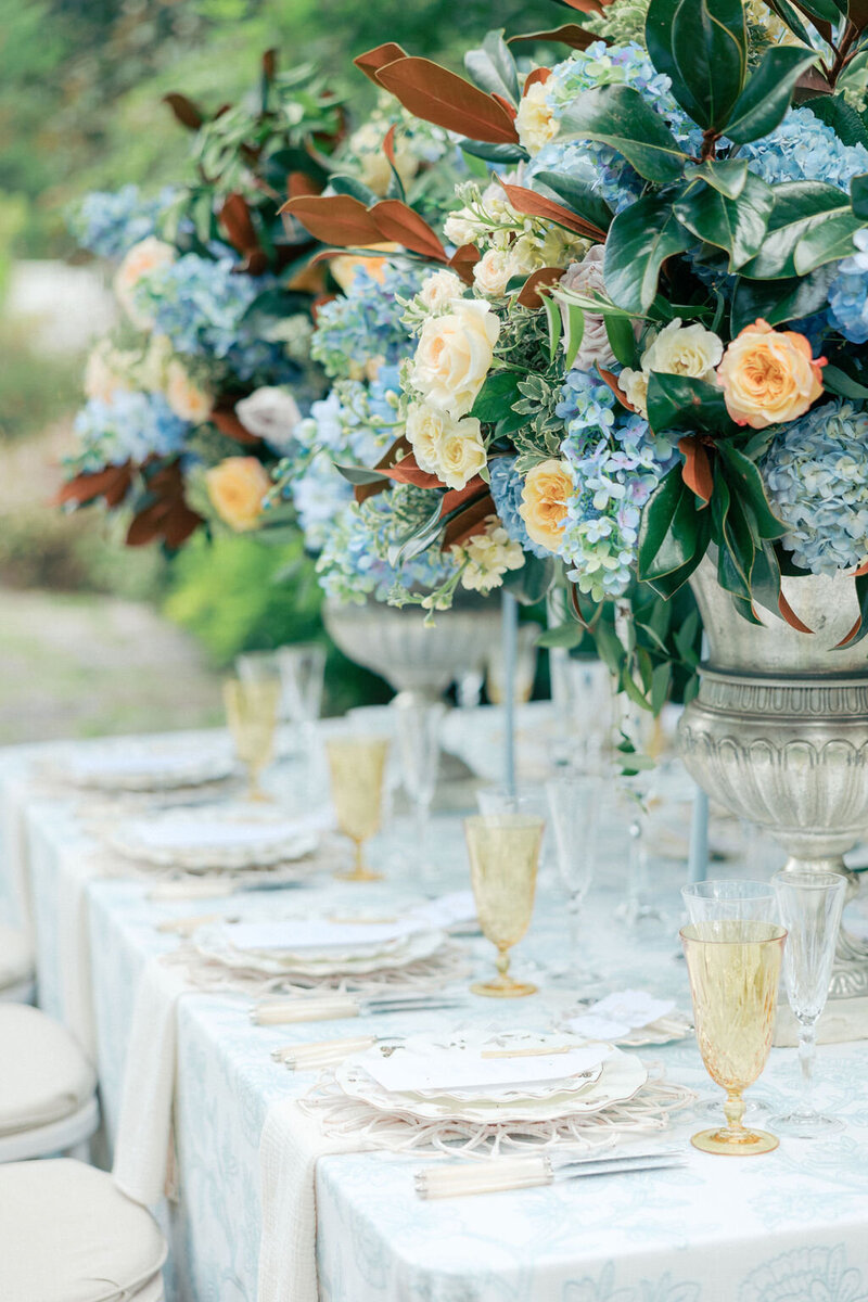 Elegant blue and white florals on wedding table with magnolio leaves
