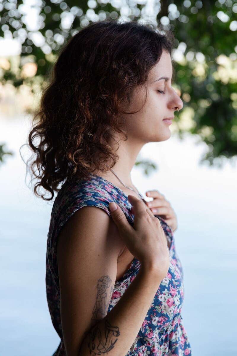 Portrait d'une jeune femme de profil les yeux fermés lors de sa séance photo portrait les pieds dans l'eau au lac de paladru