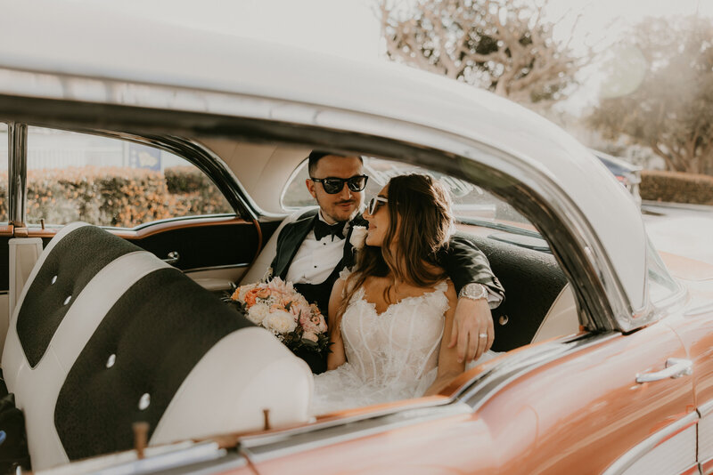 Samantha and Dillon in a vintage getaway car after their Long Beach wedding, coordinated by Beyond the Event and photographed by Kellie Jane Photography.