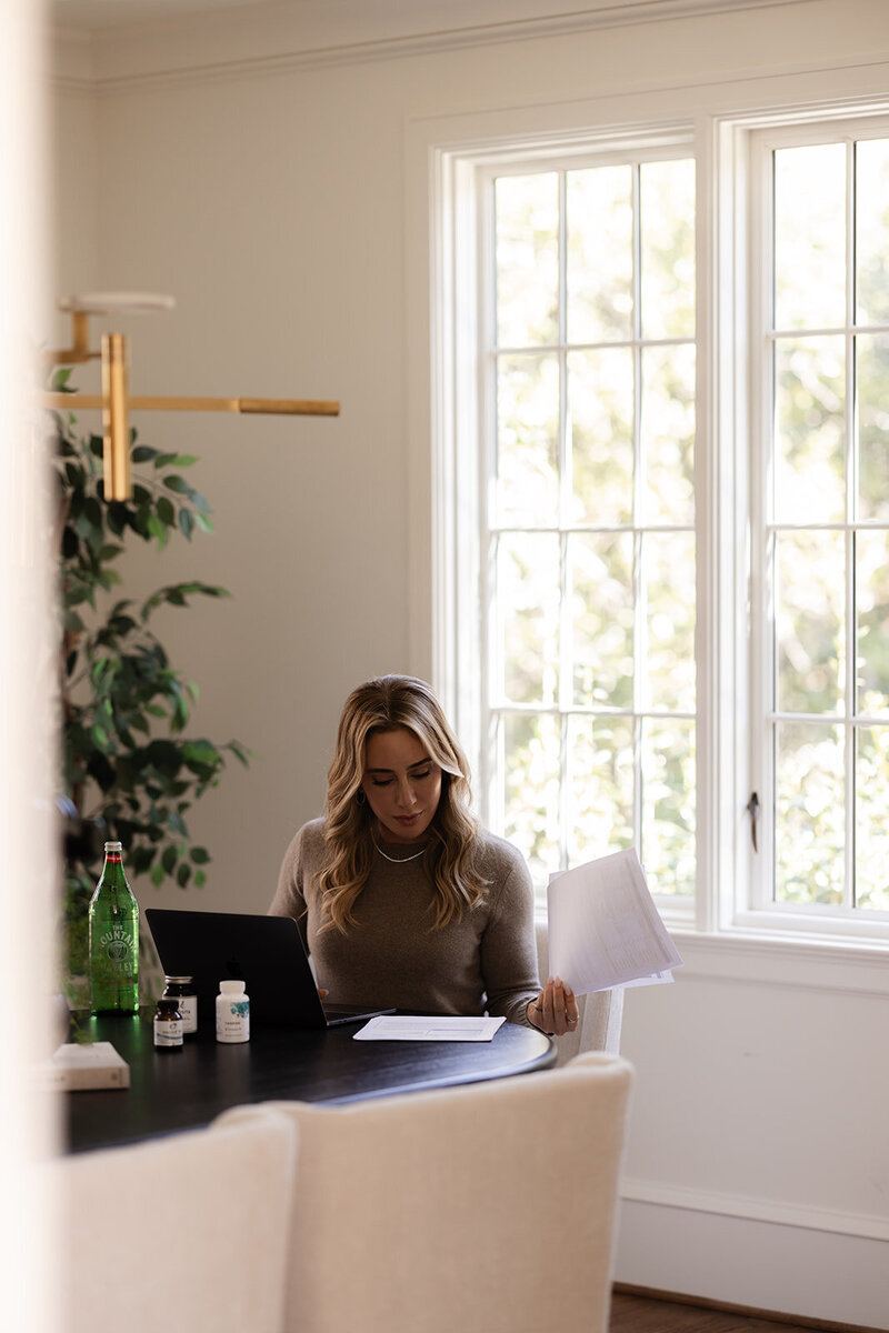 Functional dietician and nutritionist Tracy Greenstein reviewing client assessments and lab notes at her desk