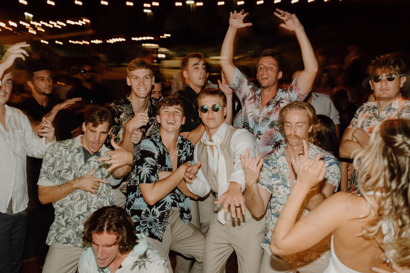 a group of men dancing at a wedding