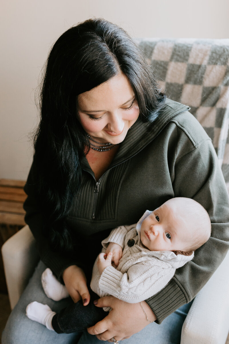 A mom rocks and cuddles her newborn baby boy. 
