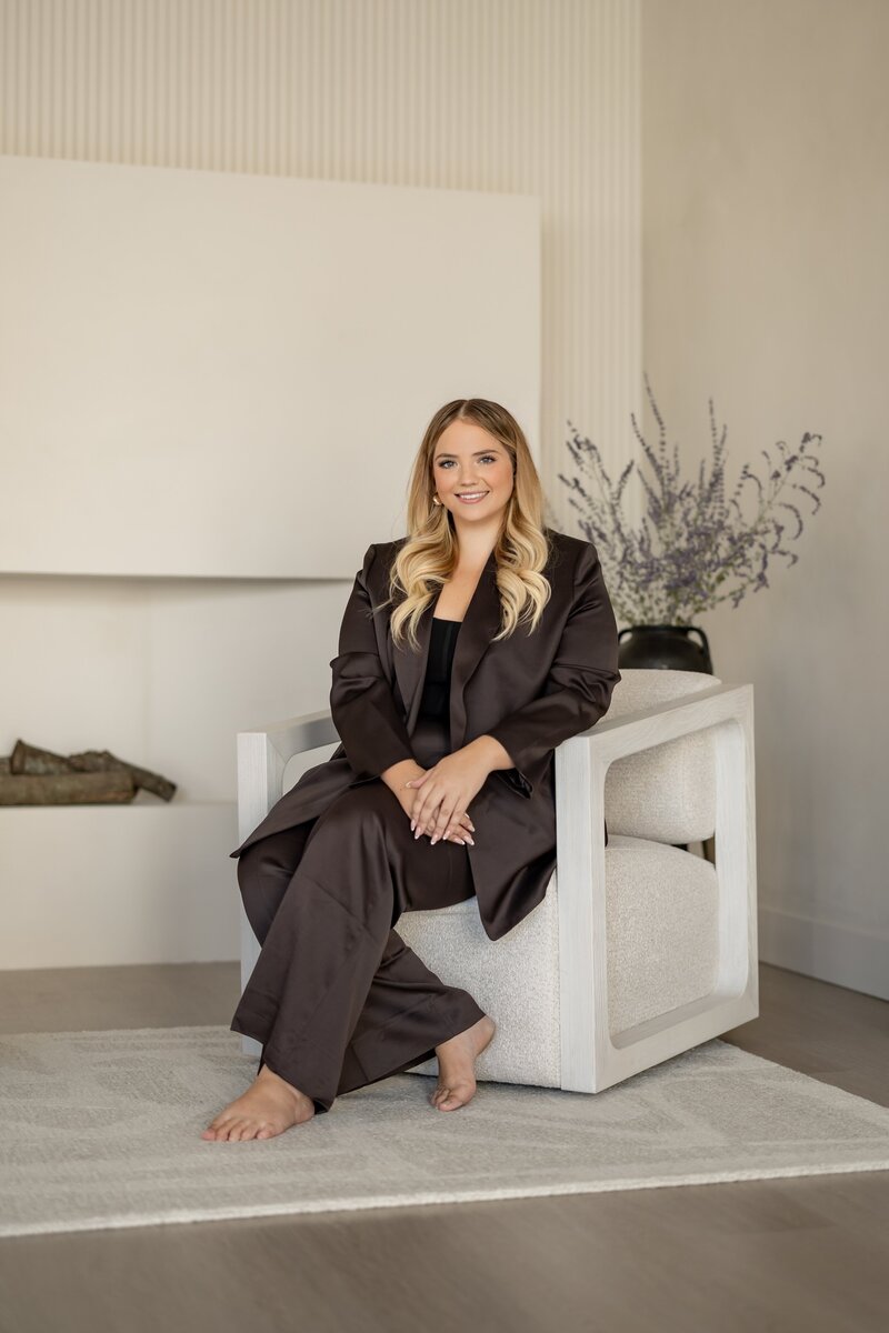 business woman sitting on sofa looking out the window with laptop on lap