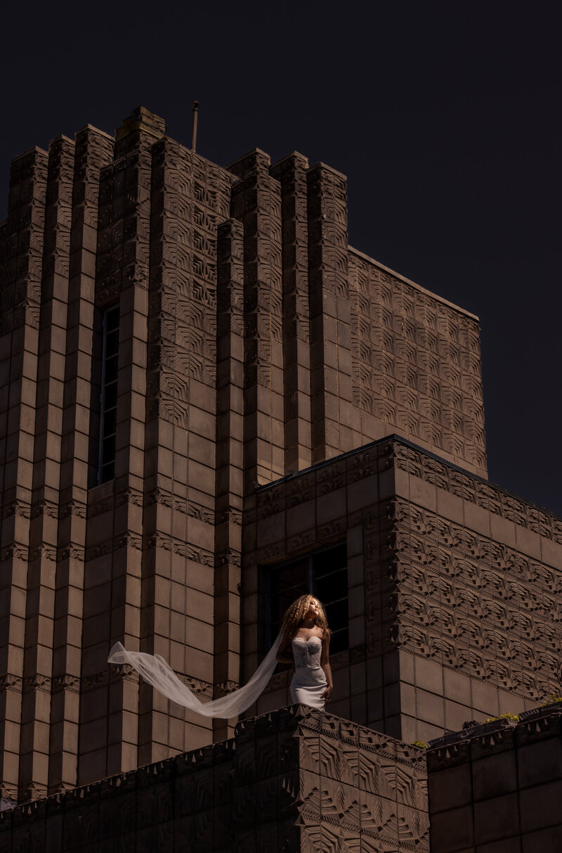 bride on a rooftop with her veil flowing in the wind