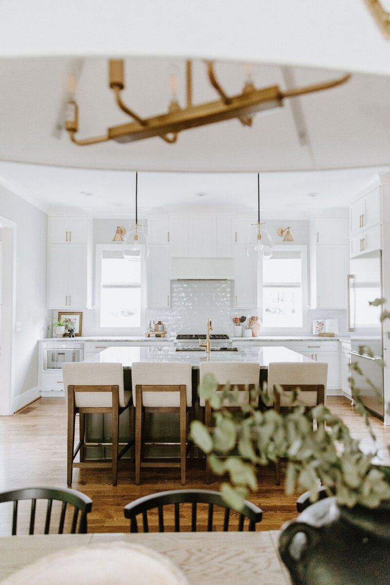 Beautiful staged white kitchen with black lights and pink flowers at open house in Raleigh, NC. Buying a Home In Fuquay Varina nc