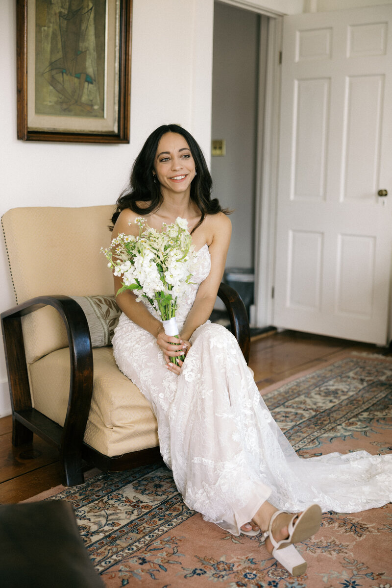 bride holding bouquet smiling at a farmhouse wedding in vermont