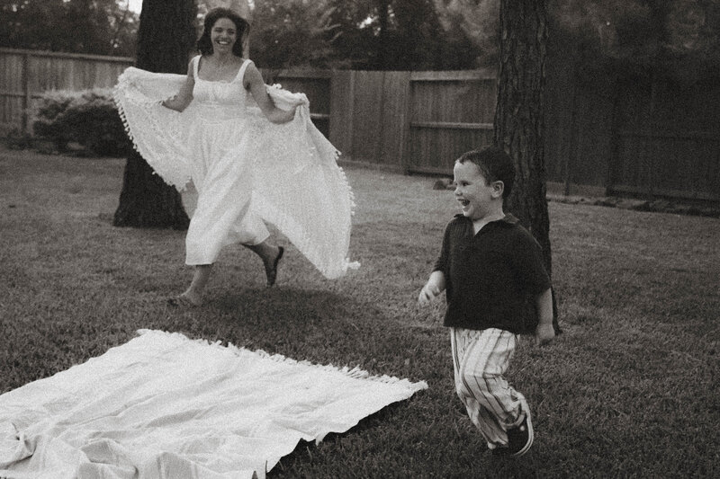 siblings playing in the sand during a family session in The Woodlands, Texas