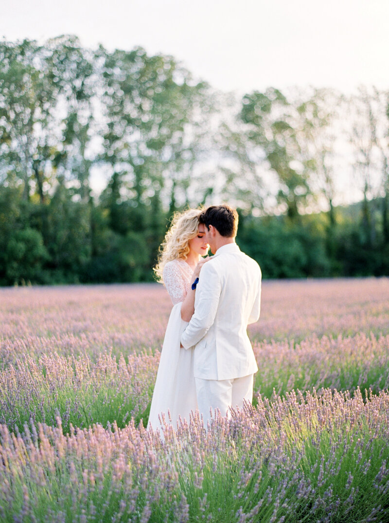 Bride and groom embrace in lavender fields in Provence